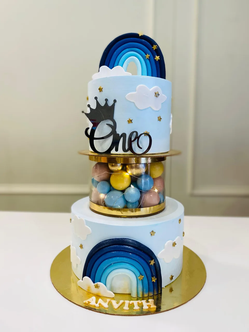 Rainbow theme two-tier first birthday cake by Simply Sweet Udaipur