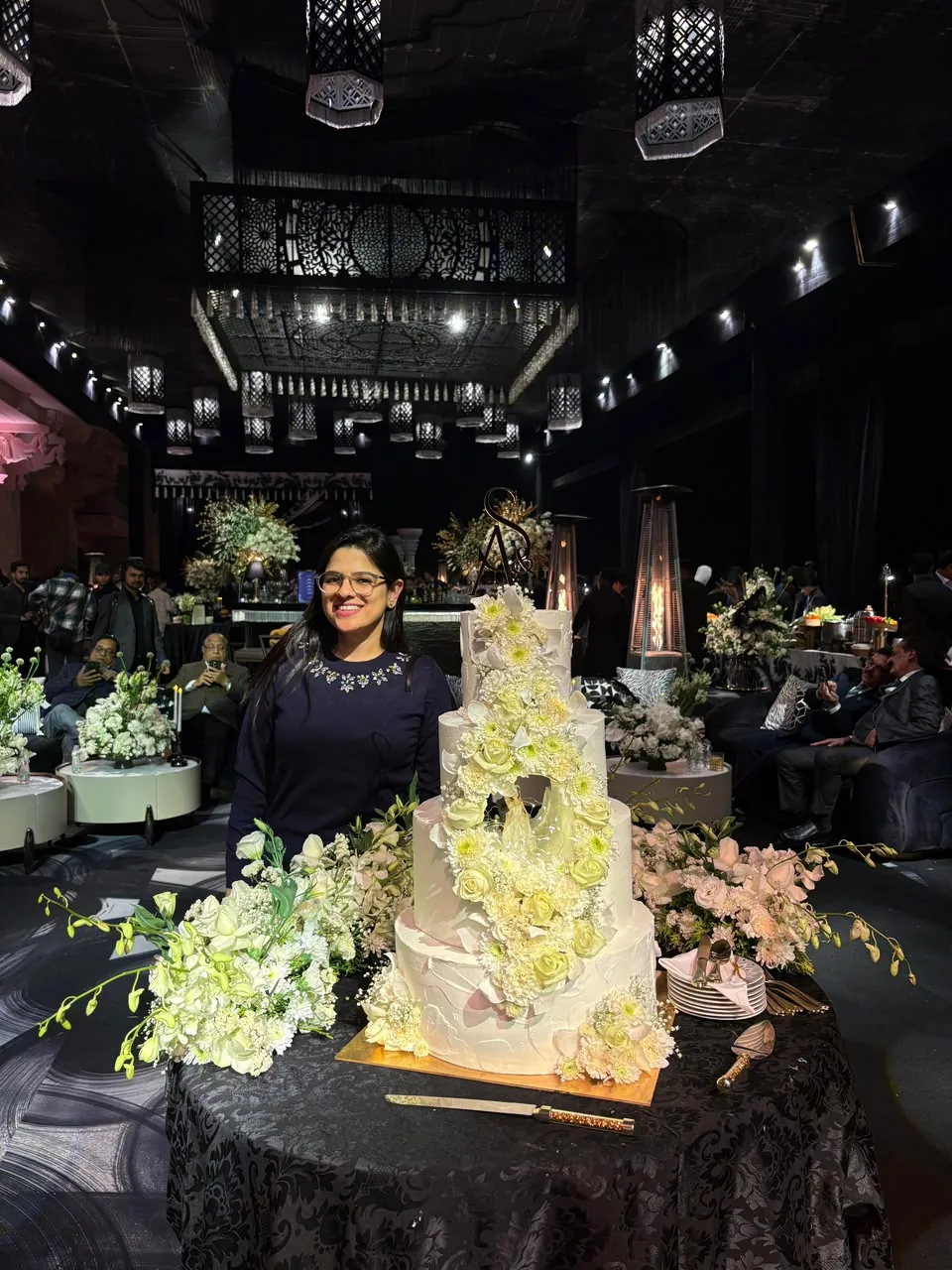 Diya Chhabra with a four-tier floral destination wedding cake by Simply Sweet Udaipur