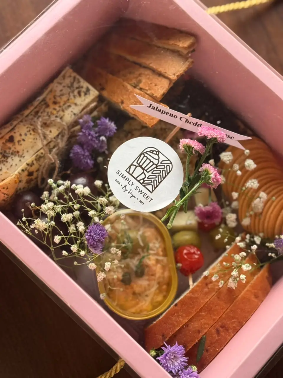 Pink grazing gift box with lavash, focaccia, dip and fresh flowers by Simply Sweet Udaipur
